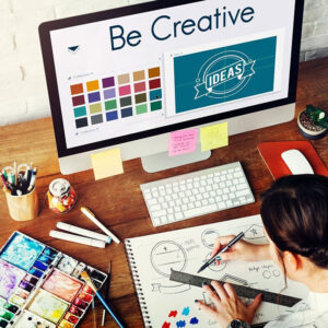 Designer sits at a computer brainstorming with color palettes and design templates