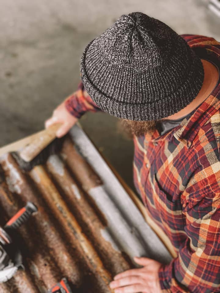 Knit hat by Alabaster Purl on a person who is working in their shop