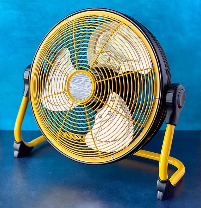 a yellow and black battery operated floor fan sits against a dual tone blue background