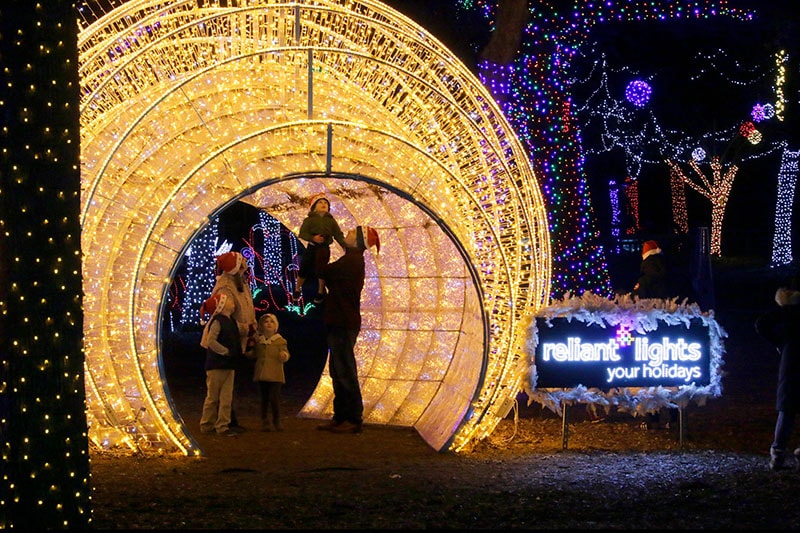 A warmly lit ornament tunnel feature at the Zoo Lights event at the Dallas Zoo