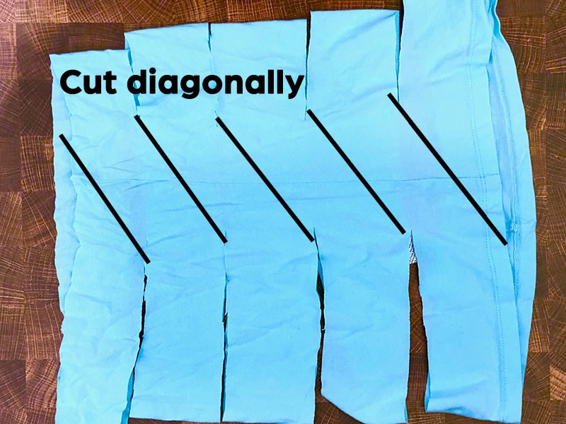 blue fabric is arranged where the top fabric loop is visible.  Cut lines are labeled in black to show a diagonal cut. 