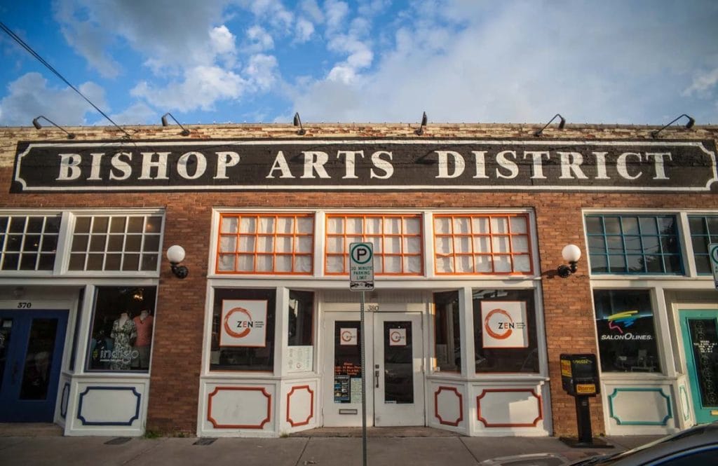 One story red brick building with a large sign that reads bishop arts district
