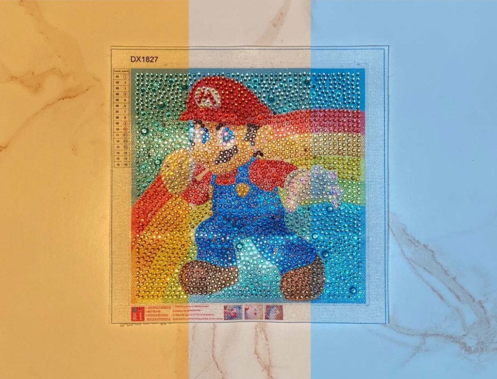A picture of a finished diamond painting canvas with super mario is shown in three different color temperatures